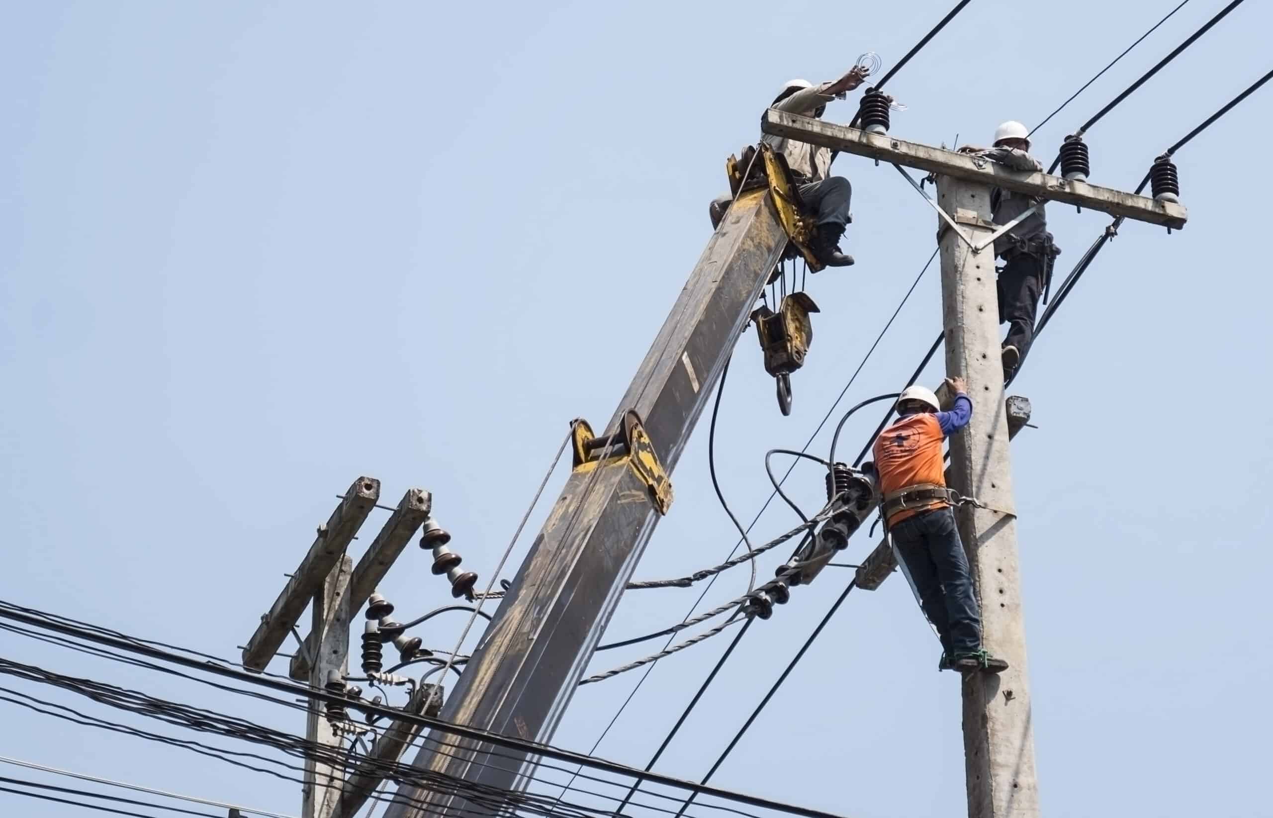 Electrical line workers repairing a power line from a utility bucket truck