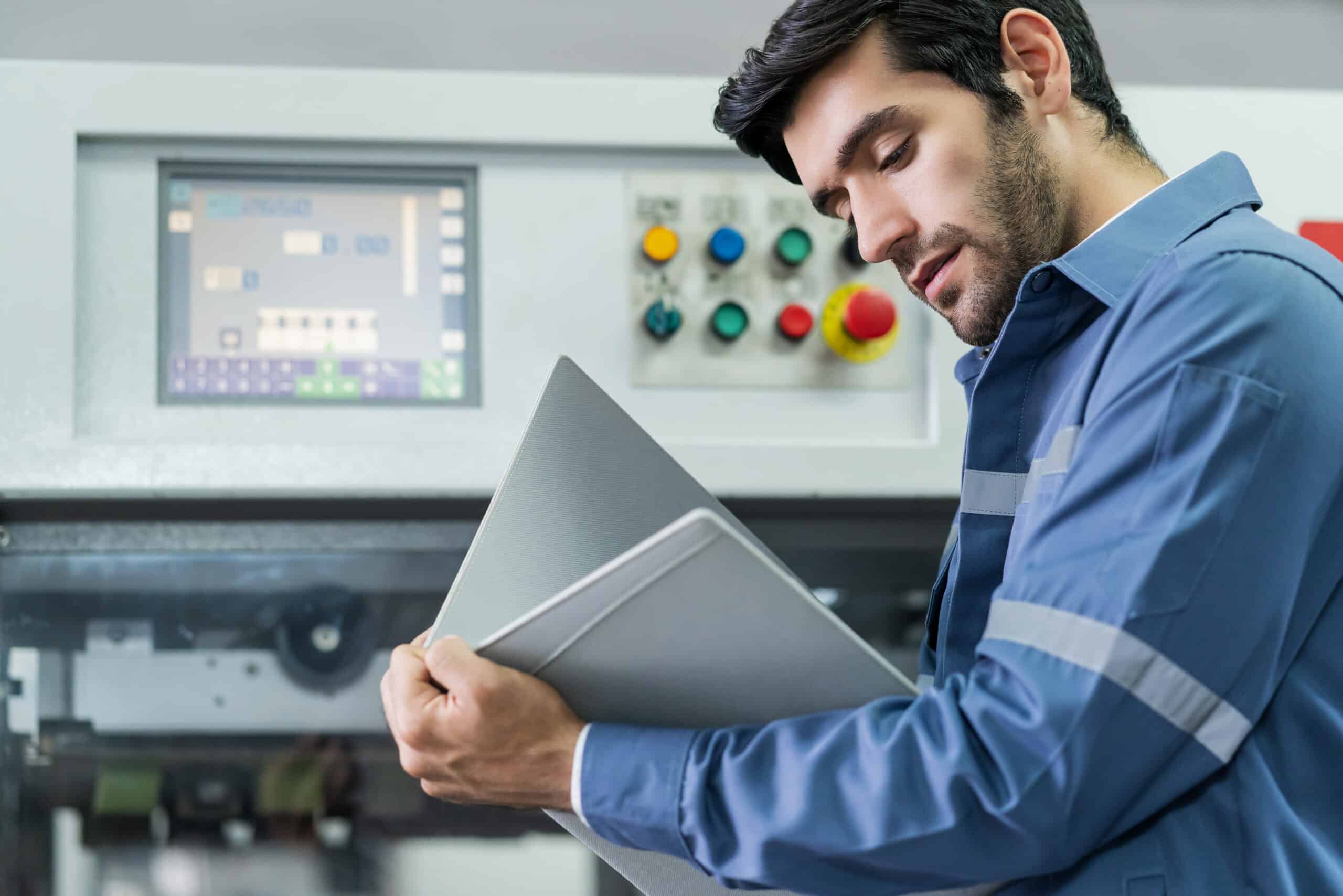 Industrial maintenance technician inspecting factory machinery