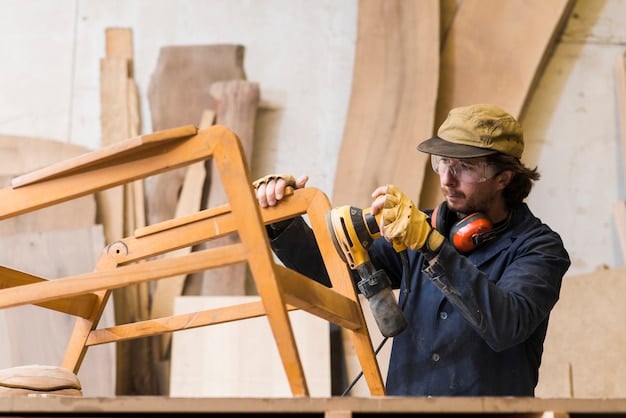 Carpenter sanding wood in a workshop
