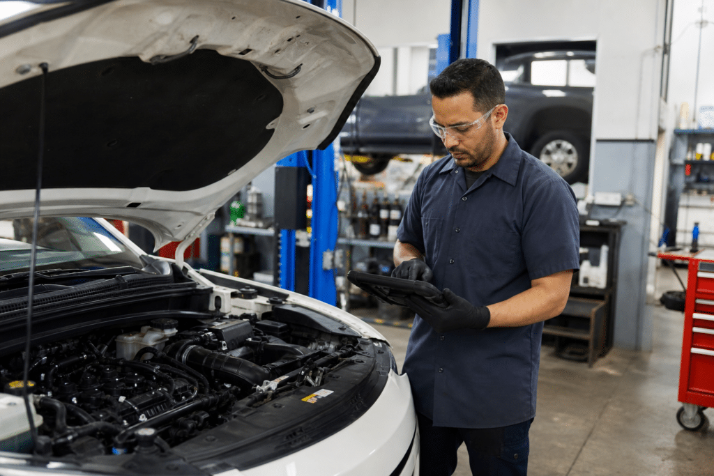 Automotive service technician diagnosing a modern car in a clean repair shop
