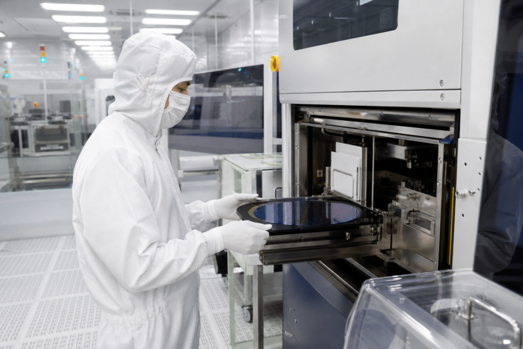 Semiconductor processing technician operating wafer equipment in a cleanroom